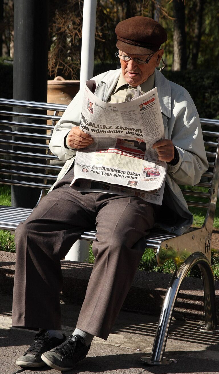 Person holding and reading a newspaper closely