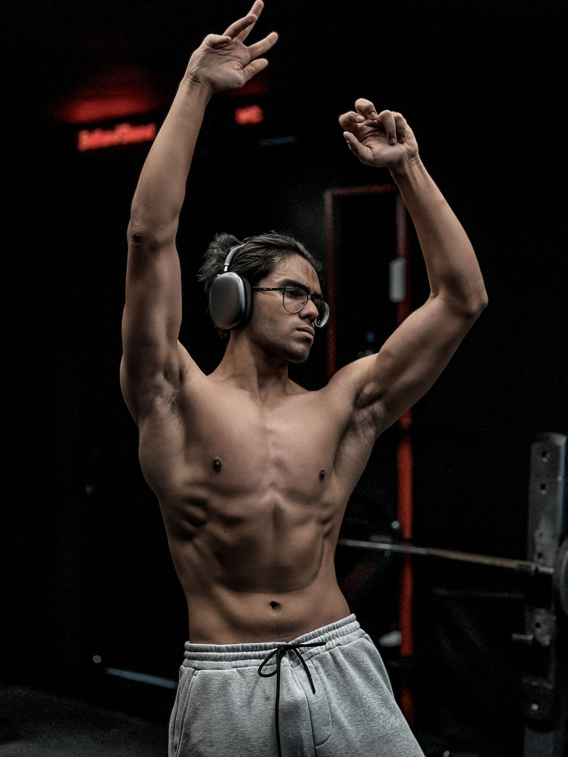 A man in a gym wearing headphones, embracing a moment of relaxation